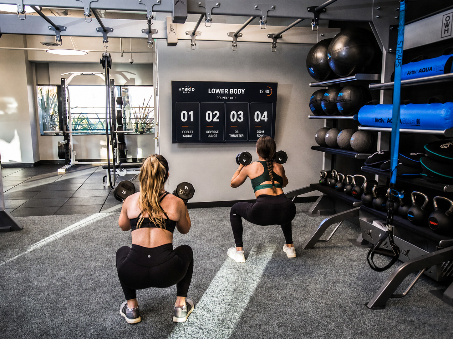 Athletes following a Hybrid Wall strength session on a gym TV